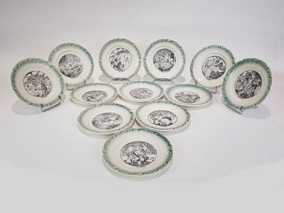 douze assiettes vertes et blanches ornées d'images en noir et blanc