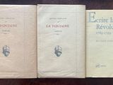 three books are lined up on a table in front of a wooden table