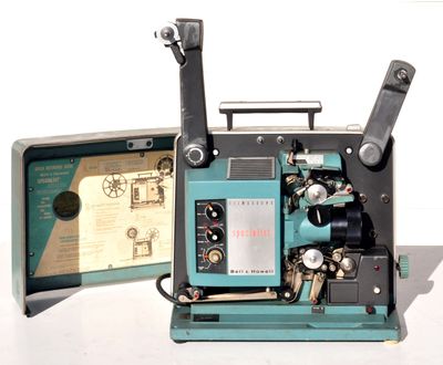 un vieux projecteur de cinéma posé sur une surface blanche