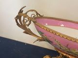 a pink and gold bowl sitting on a blue table