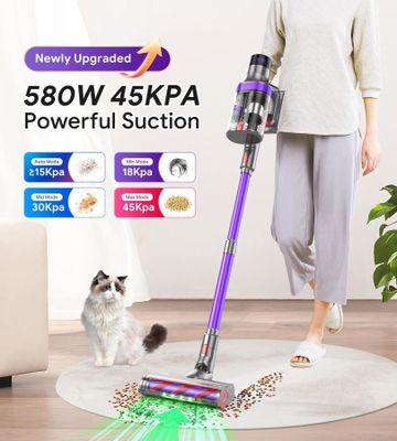 une femme debout sur le sol, avec un aspirateur et un chat