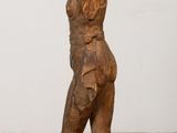 an old wooden statue of a man standing on top of a wooden block