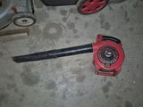 un ventilateur rouge posé par terre à côté d'un ventilateur noir