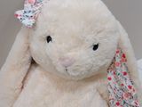 a white stuffed animal with a bow on it ' s head