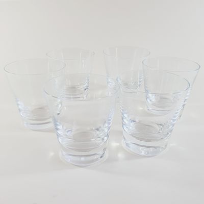 four glasses sitting on a table with a white background