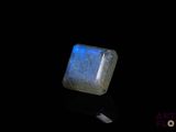 a close up of a blue and white stone on a black surface