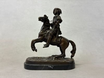 statue of a man riding a horse with a dog on it
