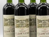 four bottles of wine are lined up on a white surface