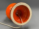 an orange and white lamp that is on a table
