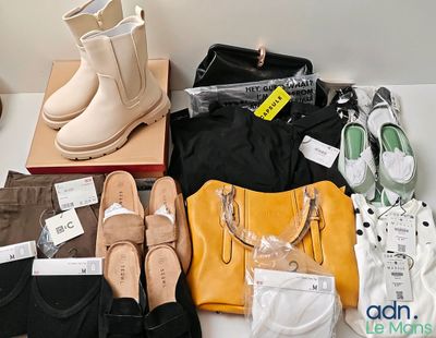 de nombreuses paires de chaussures, des sacs et d'autres objets posés sur la table