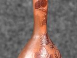 a brown vase sitting on a table with a black background
