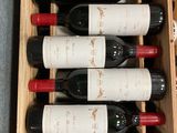 bottles of red wine in a wooden box on a table