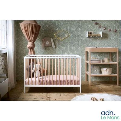 a picture of a baby ' s room with a crib and bookshelf