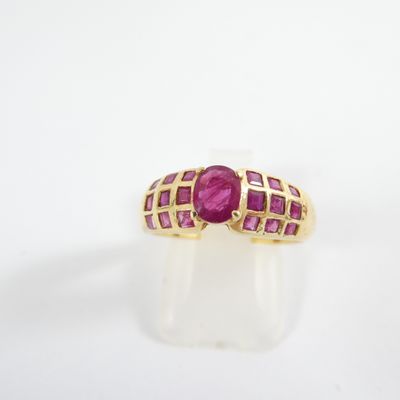a close up of a gold ring with a ruby stone
