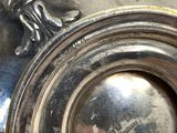 a silver vase with a handle on a table