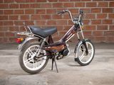 a small motorcycle parked in front of a brick wall