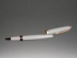 a white pen with gold trim and a black tip