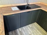 a kitchen with a black sink and wooden counter tops