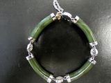 bracelet with green jade and silver beads on a black surface