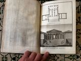 someone is holding an open book with a picture of a building in it