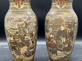 une paire de vases asiatiques ornés de scènes asiatiques, posés sur une table