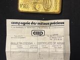 a picture of a gold bar and a certificate on a black background
