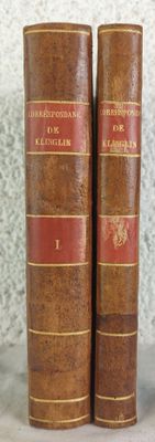 two old books sitting on top of each other on a table