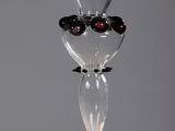 un vase en verre contenant des olives noires, posé sur une table