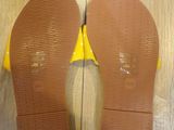 pair of brown and yellow shoes on a wooden floor