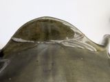 a silver vase with a handle on a white table
