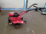 a small red lawn mower sitting in a garage