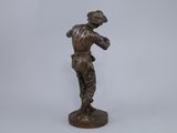 a bronze figurine of a man holding a baseball bat