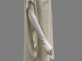 a mannequin dressed in a beige dress on a gray background