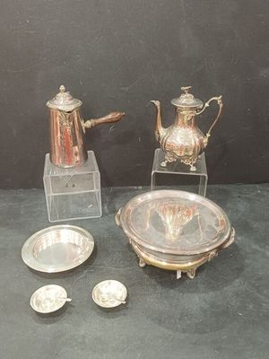 une théière en argent et une assiette en argent posées sur une table