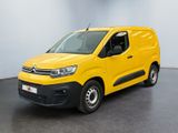 une camionnette jaune garée dans une pièce au sol noir