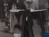 photographie en noir et blanc d'un homme portant un gros bagage