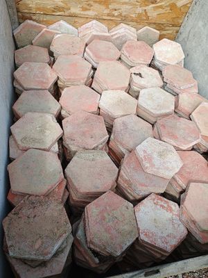 un tas de briques rouges dans une boîte posée par terre