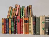 a lot of books that are stacked together on top of each other