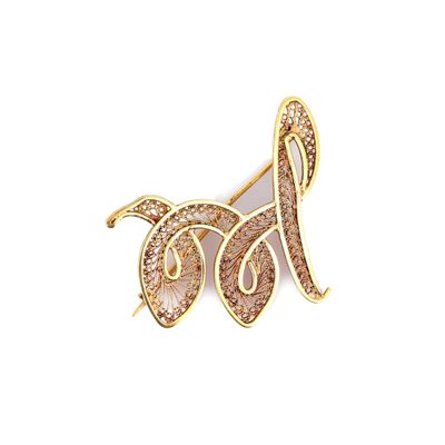 a close up of a gold and white brooch with a bird on it