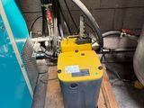 a yellow and black box sitting on a pallet next to a blue wall