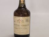 une vieille bouteille de vin de Château-Chalon posée sur une surface blanche
