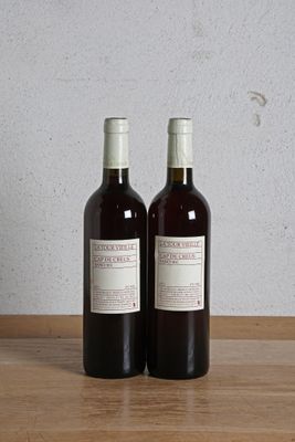 deux bouteilles de vin posées sur une table l'une à côté de l'autre