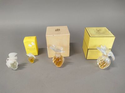 three small bottles of perfume sitting next to each other on a table