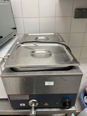 une casserole en métal posée sur une cuisinière dans une cuisine