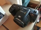 a camera that is sitting on a table next to a cell phone