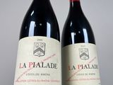 two bottles of red wine sitting next to each other on a table