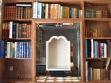 a mirror in the middle of a bookshelf with many books on it