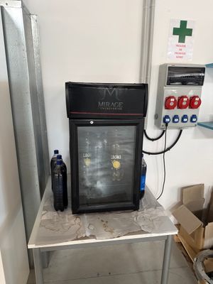 a small refrigerator sitting on a small table in a room