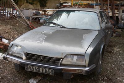 a silver car that is parked in the dirt