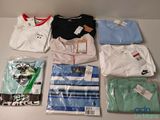 un grand nombre de t-shirts posés sur une table